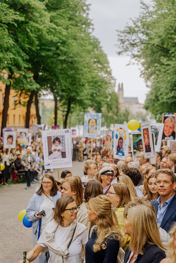 Studentskylt i handen vid utspring, firande och konfetti